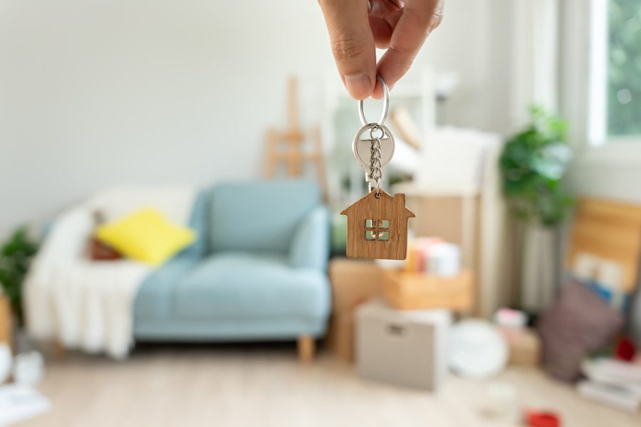 Trousseau de clés tenu devant un appartement en cours de déménagement
